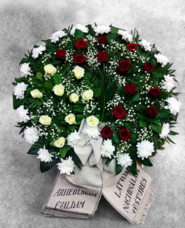A funeral wreath of freshly cut red and yellow roses and white chrysanthemums